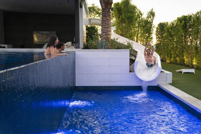 Family enjoying waterslide and swimming pool at hotel